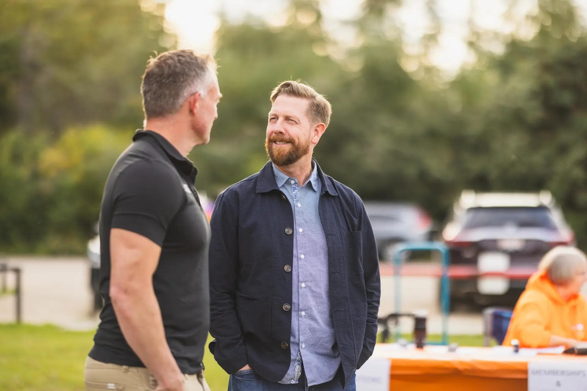 Kyle Kasawski speaking with a man in a park