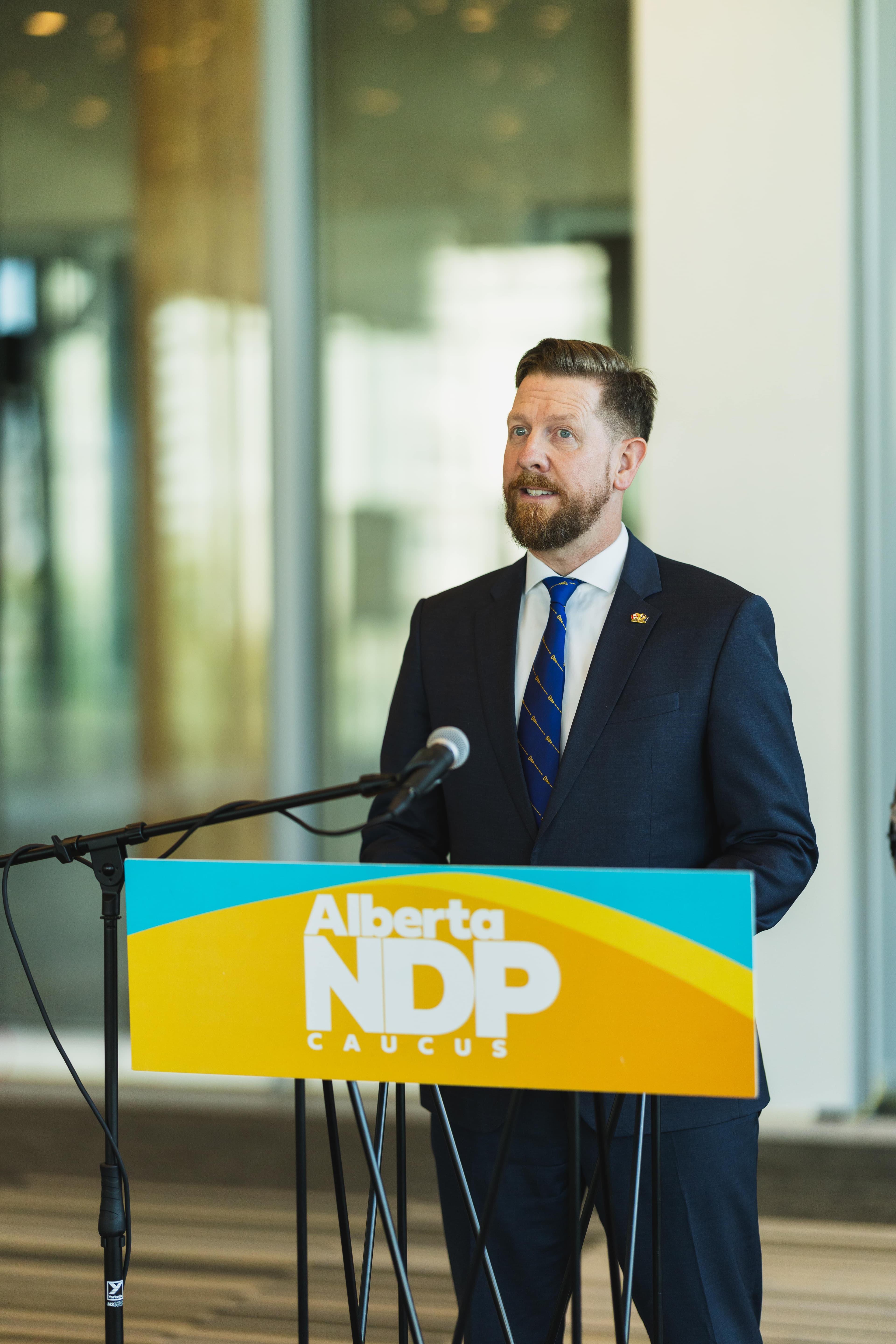 MLA Kyle Kasawski standing in a field, clapping his hands