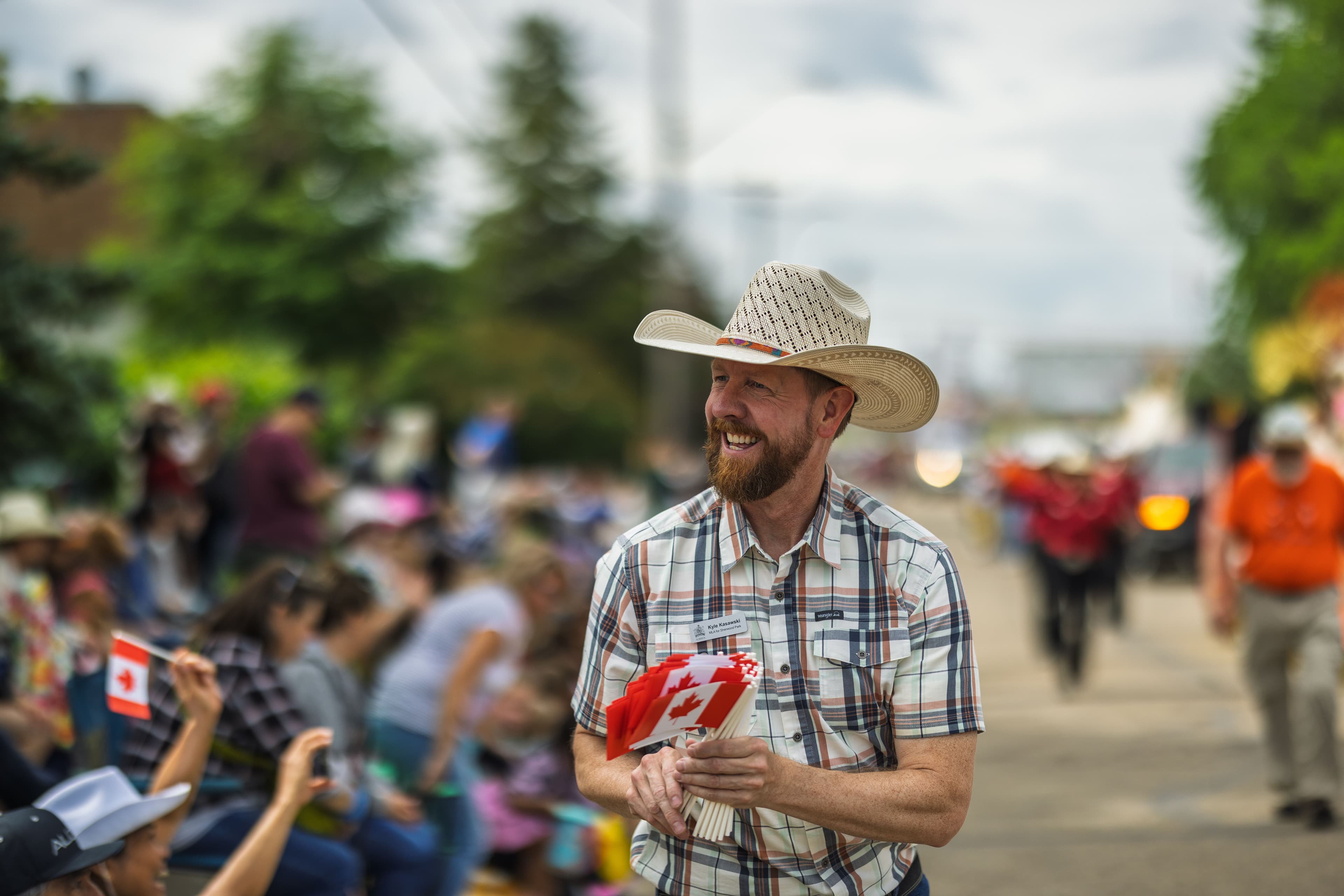 MLA Kasawski handing out Canadian flags at the Ponoka Stampede, wearing a cowboy hat.